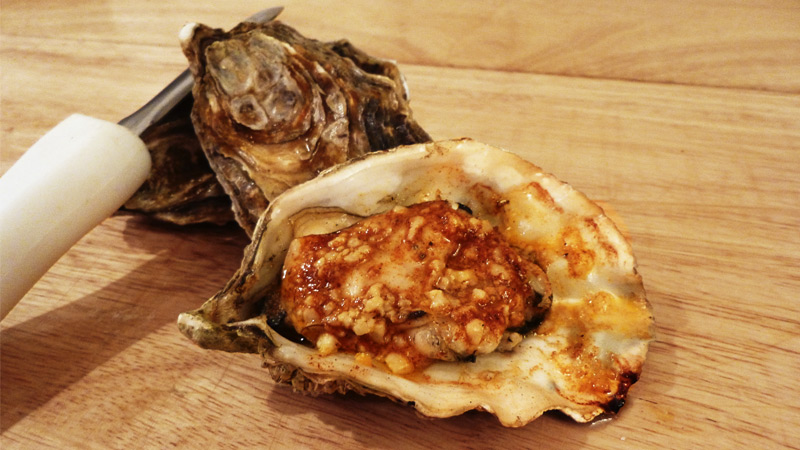 Grilled Oysters Topped with Harissa Butter Sauce